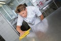 Male chef cleaning stainless steel kitchen work surface