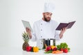 Male chef cook holding tablet computer and receipe boo Royalty Free Stock Photo