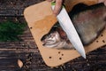 Male chef cuts raw trout on a wooden Board