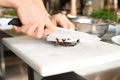 Male chef cutting black olives, closeup