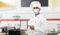 Male chef in face mask with tablet pc at kitchen Royalty Free Stock Photo