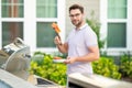 Male chef grilling and barbequing in garden. Barbecue outdoor garden party. Handsome man cook preparing barbecue salmon