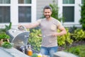 Male chef grilling and barbequing in garden. Barbecue outdoor garden party. Handsome man preparing barbecue meat Royalty Free Stock Photo