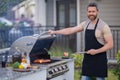 Male chef grilling and barbequing in garden. Barbecue outdoor garden party. Handsome man preparing barbecue meat