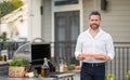 Male chef grilling and barbequing salmon fillet in garden. Barbecue outdoor garden party. Handsome man preparing Royalty Free Stock Photo