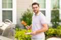 Male chef grilling and barbequing salmon in garden. Barbecue outdoor garden party. Handsome man cook preparing barbecue