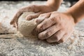 Male chef hands knead dough with flour on kitchen table Royalty Free Stock Photo