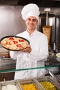 Male chef with Italian pizza at bistro Royalty Free Stock Photo