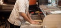 Male chef kneading and rotating dough basis for pizza Royalty Free Stock Photo