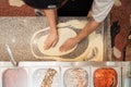 Male chef kneading and rotating dough basis for pizza Royalty Free Stock Photo