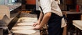 Male chef kneading and rotating dough basis for pizza Royalty Free Stock Photo