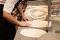 Male chef kneading and rotating dough basis for pizza Royalty Free Stock Photo