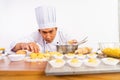 male chef looks and carefully examines cake on tray