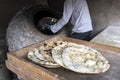 male chef makes bread in shape of heart. Traditional Arabic bread baking on coals in tandoor Jordan. Jerash. Large flat