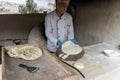 A male chef makes bread in the shape of a heart. Traditional Arabic bread baking on coals in tandoor Jordan. Jerash