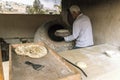 A male chef makes bread in the shape of a heart. Traditional Arabic bread baking on coals in tandoor Jordan. Jerash