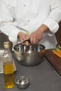 Male Chef Peeling Carrots In Mixing Bowl