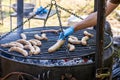 Male chef preparing sausages on the barbecue grill, street food, summer food festival. Fresh sausage and hot dogs grilling Royalty Free Stock Photo