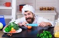 Male chef preparing tasty fresh vegetable salad. Chef with sharp knife cuts tomato. Diet, healthy food cooking Royalty Free Stock Photo