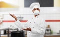 Male chef in respirator at restaurant kitchen