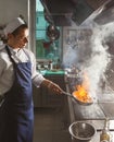 Chef cooking meat at restaurant or hotel kitchen