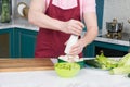 Male chef salting vegetable salad. Cook adding salt to salad with mushrooms and paprika. Man at kitchen preparing dinner. Royalty Free Stock Photo