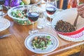 Male chef serving organic vegan salad for dinner - Cook man preparing the table for meal with vegetarian food and ecologic wine - Royalty Free Stock Photo