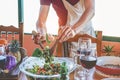 Male chef serving organic vegan salad for dinner - Cook man preparing the table for meal with vegetarian food and ecologic wine - Royalty Free Stock Photo