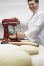 Male Chef Using Dough Mixer In Kitchen