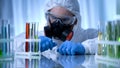 Male chemist checking test tubes with biohazard substance, toxicology testing