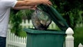 Male citizen throwing garbage in trash can, preventing littering, environment