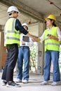 Male civil engineer shaking hands with a female construction inspector in the construction site