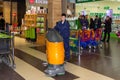 A male cleaner with a floor washer cleans floors in a shopping center