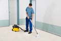 Male Cleaner Vacuuming Floor