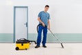 Male Cleaner Vacuuming Floor