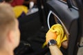 Male cleaner wiping dust in interior of car with microfiber cloth closeup Royalty Free Stock Photo