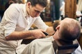 Male client with beard sitting in hairdresser chair. Serious man with long brown beard. Modern popular lumberjack style. Royalty Free Stock Photo