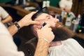 Male client with beard sitting in hairdresser chair. Serious man with long brown beard. Modern popular lumberjack style. Royalty Free Stock Photo