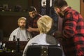 Male client getting haircut by hairdresser in barber shop. Royalty Free Stock Photo