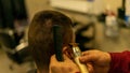 Male client getting a haircut by the hairdresser with an electric shaver in a barbershop Royalty Free Stock Photo