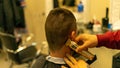 Male client getting a haircut by the hairdresser with an electric shaver in a barbershop Royalty Free Stock Photo