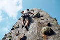 male climber climbs on a rocky wall against the blue sky