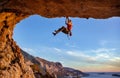 Male climber gripping on handhold while climbing in cave.