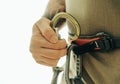 Male climber holds a carabiner in his hand.