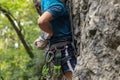 Male climber reaching for magnesium while hanging on a rope in the mountains