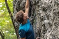 Male climber reaching up while ascending the rock wall