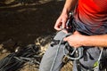 A male climber ties a safety knot eight on the harness before climbing the track. Climbing equipment: rope, quickdraw, safety Royalty Free Stock Photo