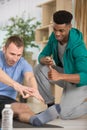 male coach helping man to stretch hsi muscles