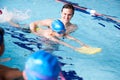 Male Coach In Water Giving Group Of Children Swimming Lesson In Indoor Pool Royalty Free Stock Photo