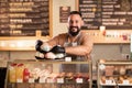 male coffee shop owner near showcase with cakes and desserts in his cafe, work in the cafeteria Royalty Free Stock Photo